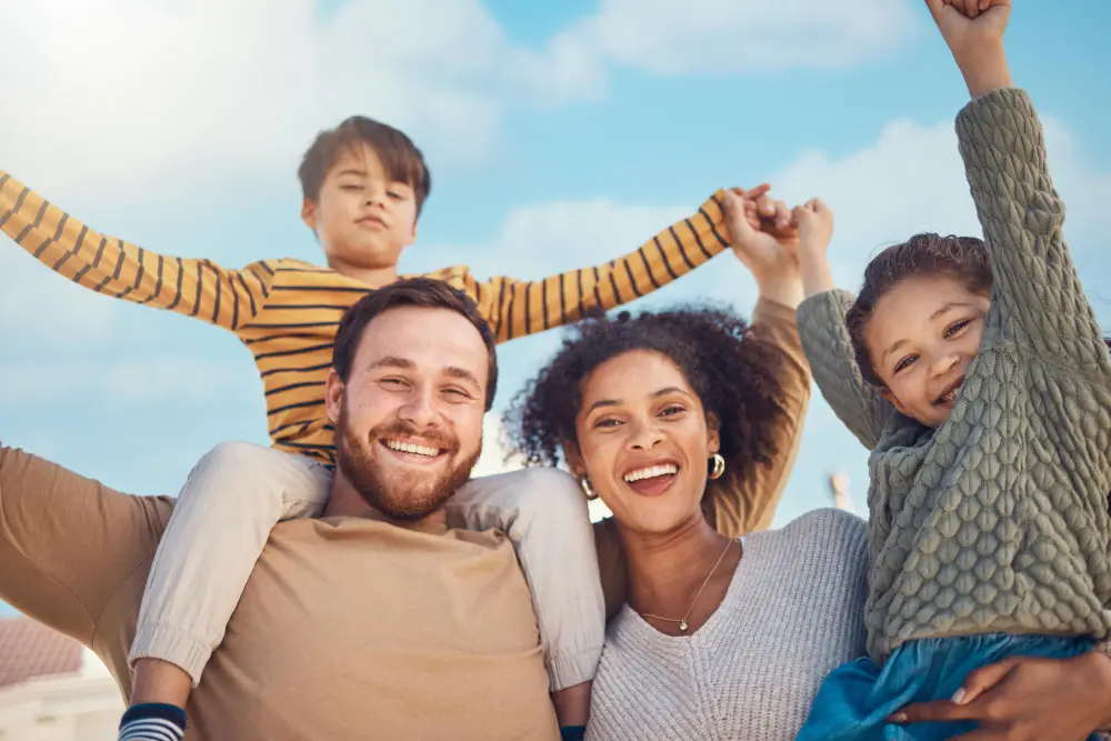 Young family outside in the sunshing having fun and smiling.