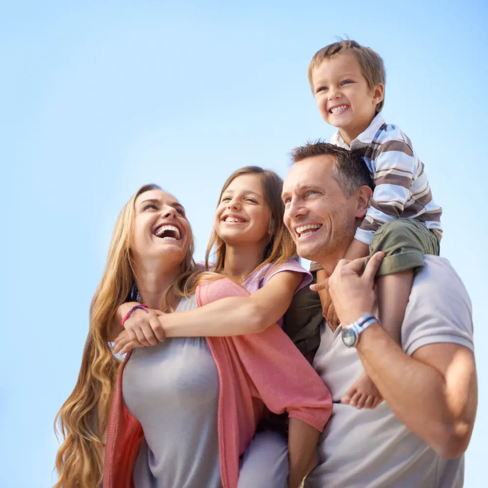 Family smiling at each other outdoors.